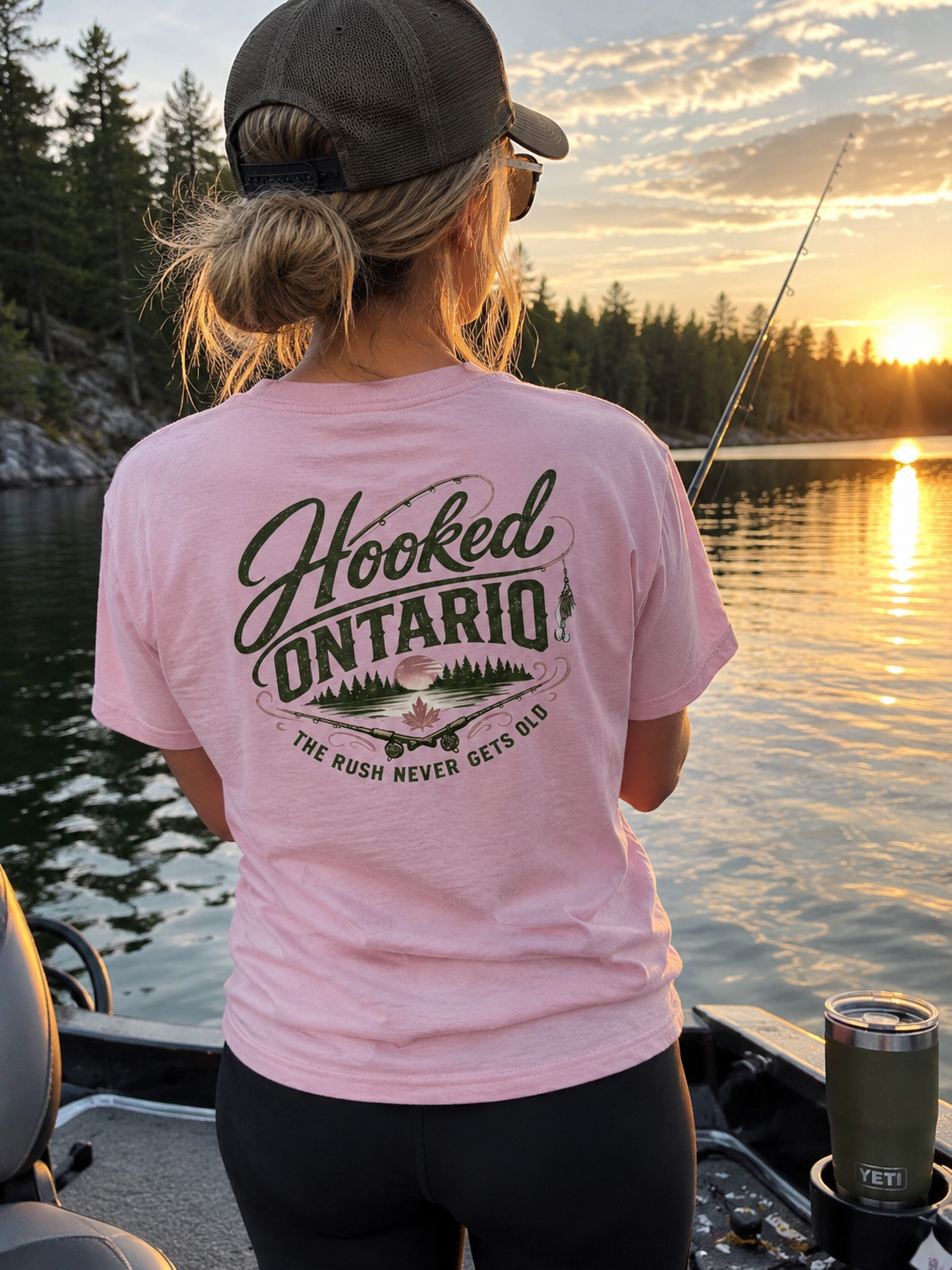 Angler in a pink Hooked Ontario 'The Rush Never Gets Old' tee at sunset